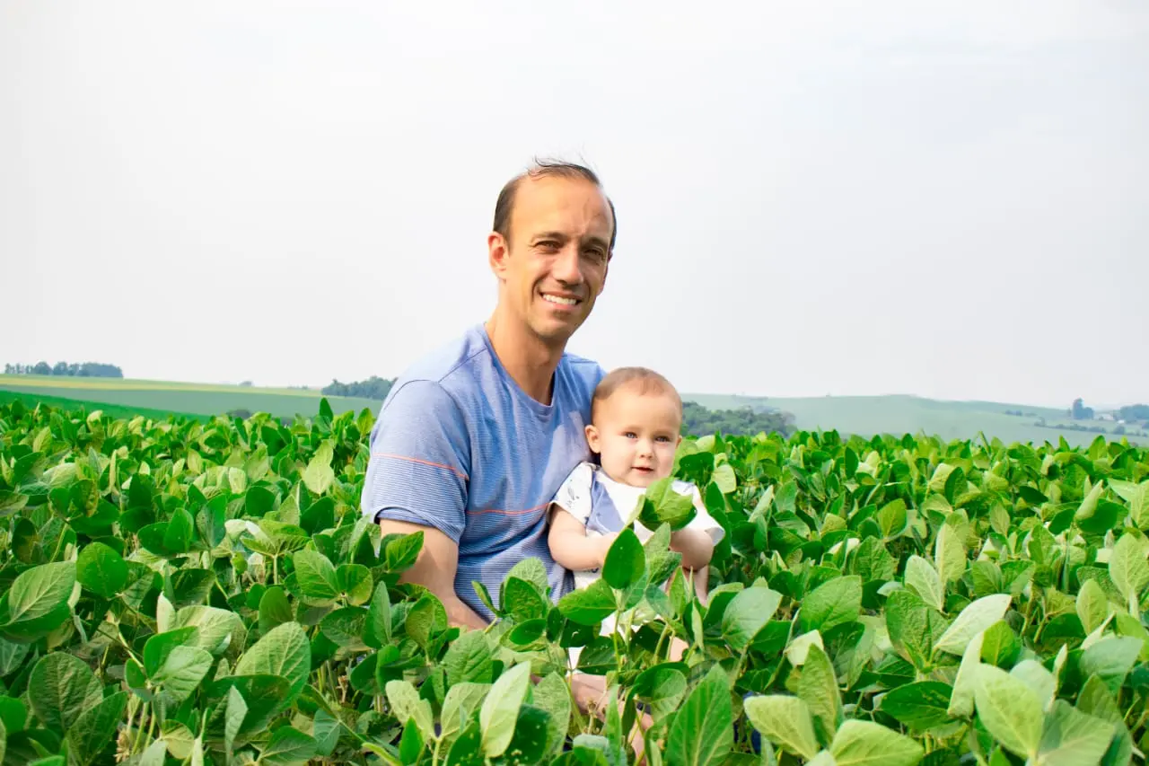 Gabriel Colle com o filho em uma lavoura de soja