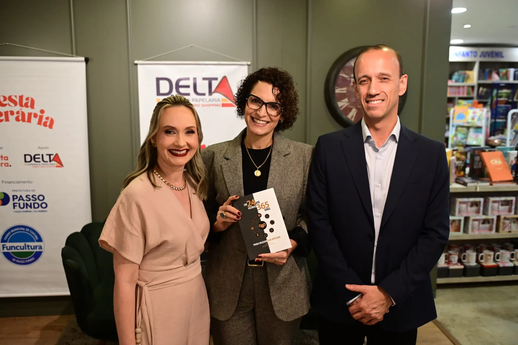 Gabriel e Graciela com uma leitora de óculos segurando seu exemplar na Livraria Delta