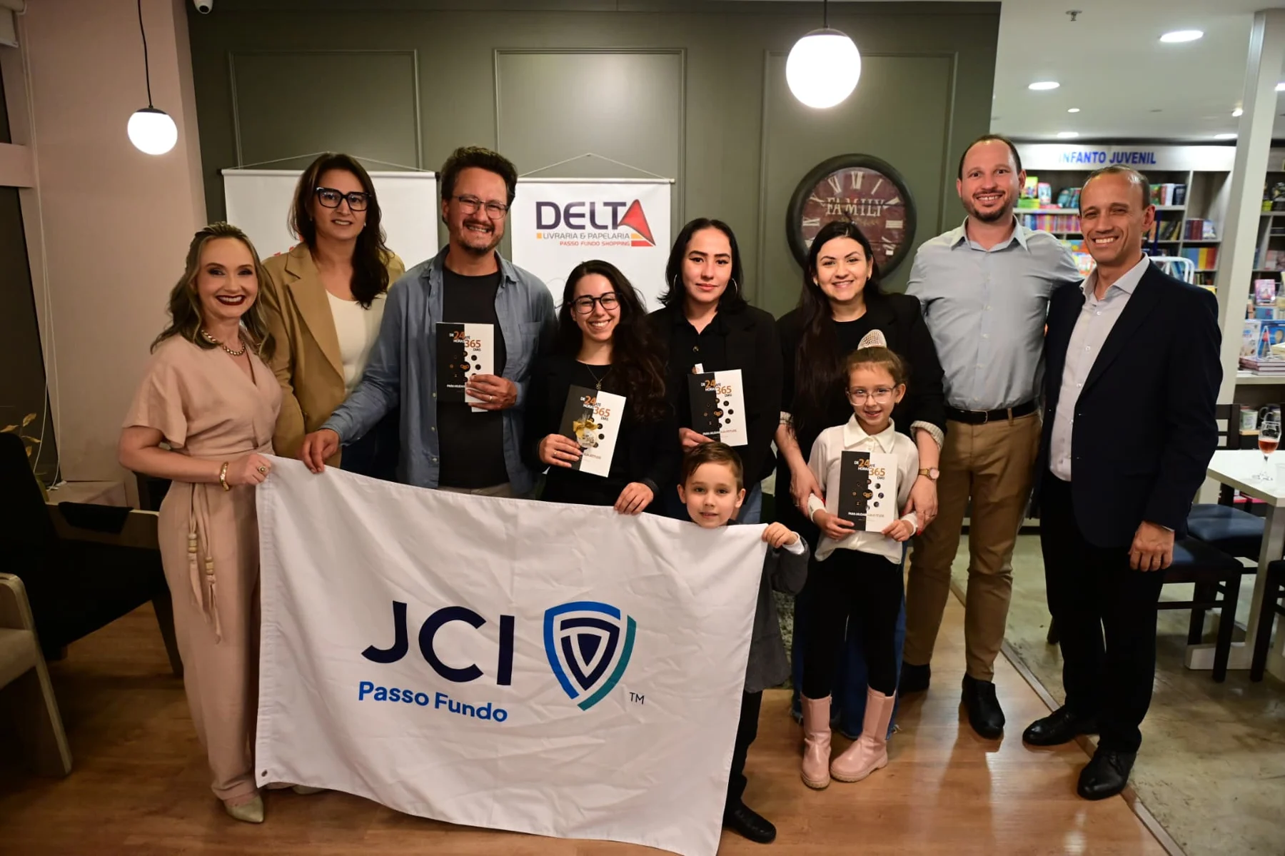 Autores e leitores reunidos com exemplares do livro e a bandeira da JCI Passo Fundo